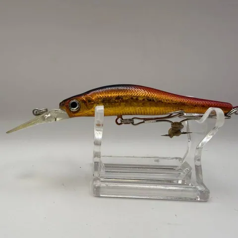 Wobler typu minnow z czarnym grzbietem, czerwonymi bokami, złotym brzuchem